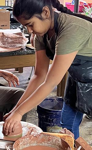 middle school student making pottery